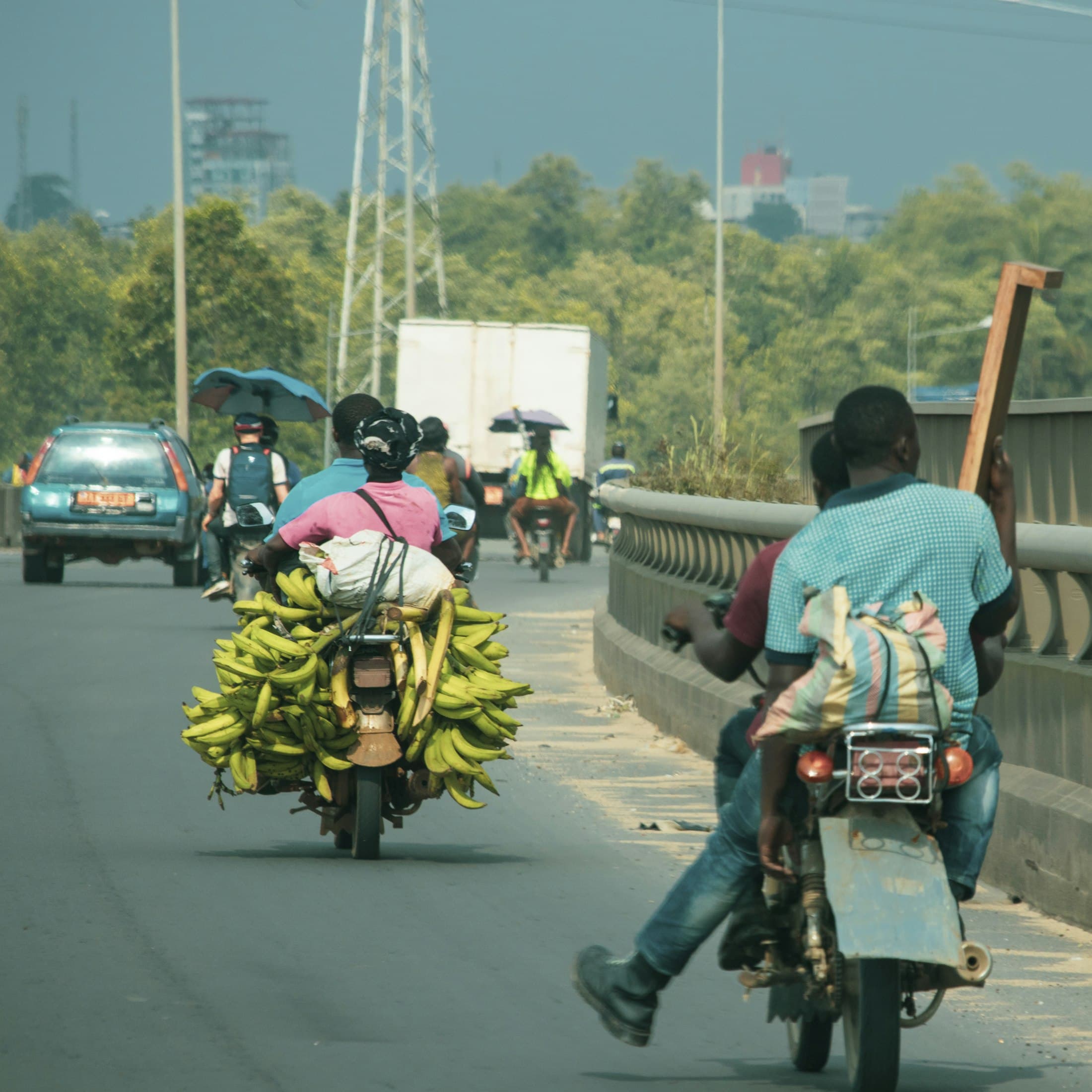 Motorbikes carrying goods across a bridge in Douala